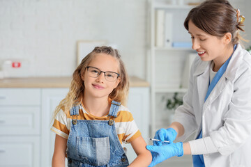 Little girl receiving vaccine from doctor in clinic