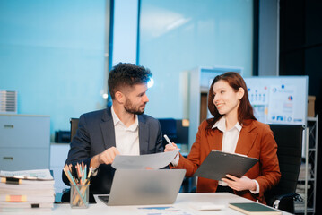 Female discussing new project with male colleague. Young woman talking with young man