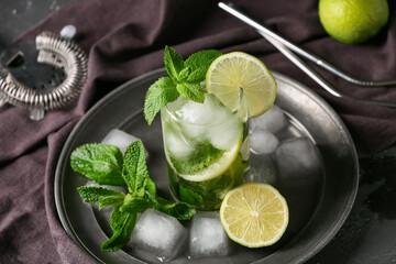 Glass of fresh Mojito cocktail with mint and ice cubes on black background, closeup