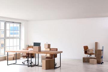 Workplace with chairs and cardboard boxes in office on moving day