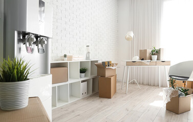 Workplace and shelf unit with cardboard boxes in office on moving day