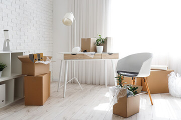 Workplace with cardboard boxes in office on moving day