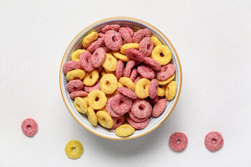 Bowl with color cereal rings on white background, closeup