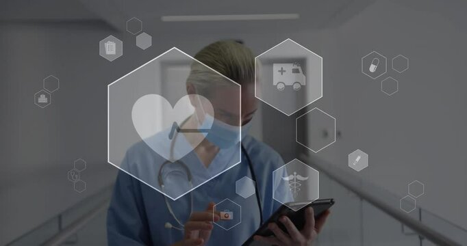 Female healthcare worker lifting hand and tapping tablet showing medical icons while reviewing data