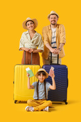 Family of tourists with passports and suitcases on yellow background
