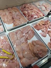 Fresh Raw Chicken Cuts Displayed in a Supermarket Refrigerator