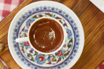 top view of turkish coffee served in decorative cup on wooden table