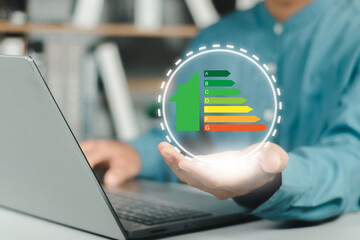 Person hand holding house icon with energy efficiency scale image on blue bokeh background, Concept of ecological and bio energetic house. Energy class.