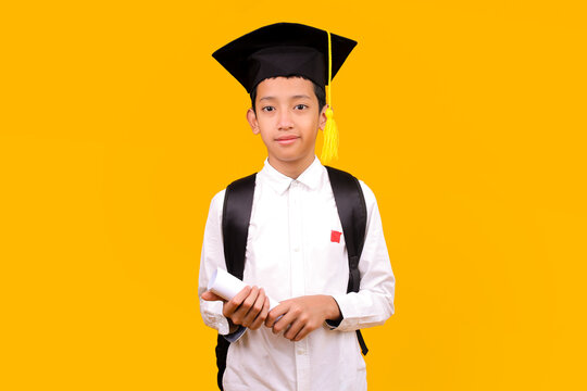 Young Asian Student With Backpack And Graduation Cap Holding Rolled Diploma Or Certificate