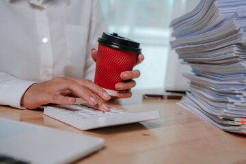 Fototapeta premium An office worker in a white shirt organizes a large stack of documents with colorful paper clips and folders.