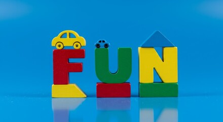 Colorful wooden blocks spelling out FUN with toy cars and house