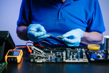 The technician is putting the CPU on the socket of the computer motherboard. electronic engineering...