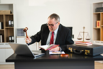 Mature Male judge in a courtroom on white table and Counselor or Male lawyer working in office. Justice and law concept