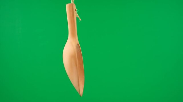Hanging light brown object against green background