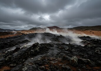 Volcanic landscape featuring rugged terrain composed of dark, jagged lava rocks. Wisps of steam rise from the fissures in the ground, suggesting geothermal activity.