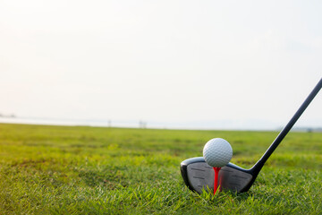 Golf clubs and golf balls on a green lawn in a beautiful golf course