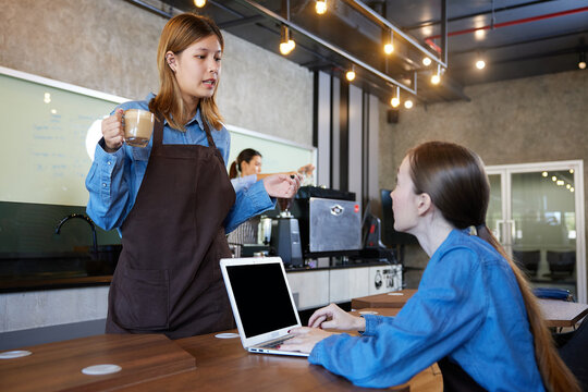 young baristas meeting and talking about work in the cafe