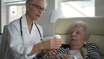 Obraz premium A health professional provides medication instructions to an elderly woman during a home visit. The interaction emphasizes care and attention to health needs.