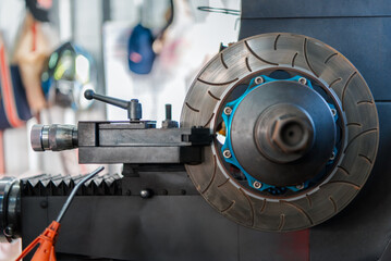 Car mechanic or serviceman disassembly and checking a disc brake and asbestos brake pads for fix and repair problem at car garage or repair shop
