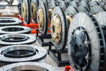 Car mechanic or serviceman disassembly and checking a disc brake and asbestos brake pads for fix and repair problem at car garage or repair shop