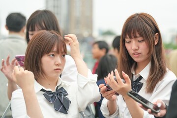 In early summer in Shanghai, near The Bund, Japanese high school girls in uniforms chat and laugh...