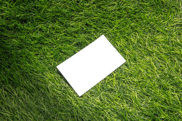 Clean white paper rests on vibrant green artificial grass for an inviting, fresh appearance.