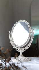 An elegant, decorative, off-white vanity mirror on a table top used as device mockup