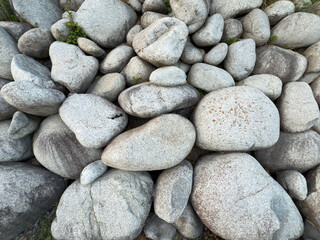Close-up of natural Tatra granite stones with rough texture and rounded shapes, commonly used in...