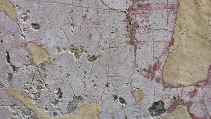 Pompeii between the theatres, Italy - 8 January 2025. Faded red and beige plaster wall etched with...