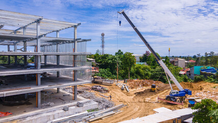 Construction crane and steel frame of a new commercial building under construction