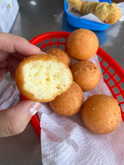 Buñuelos en Cesta Roja con Uno Mordido
