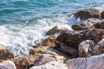 Coastal foamy waves crashing on the rocks on the Athens promenade