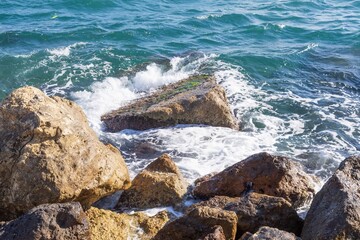 Coastal foamy waves crashing on the rocks on the Athens promenade