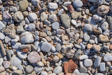 Top view of natural pebble stones on the shore of a Mediterranean beach. Nature background for design