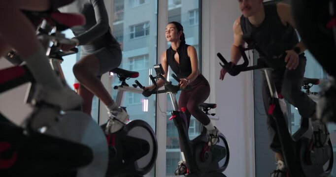 Cycling, spin class and people in gym with lights for cardio workout, exercise and training. Sports, health club and group on bike machine for endurance, core strength and challenge for wellness