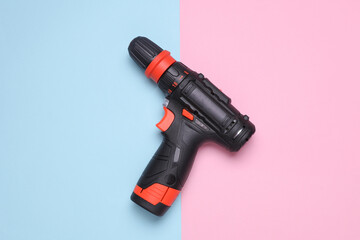 Cordless screwdriver on a blue and pink background. Top view
