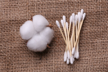 Cotton swabs and cotton flowers on burlap. Personal hygiene