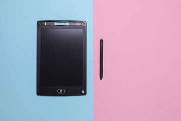 Children's black drawing tablet on a blue pink background