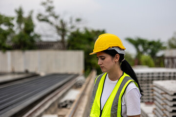 Female civil engineer is conducting a quality check in a precast factory. Engineer in safety suit...