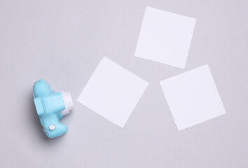 Toy plastic camera with blank cards on white background