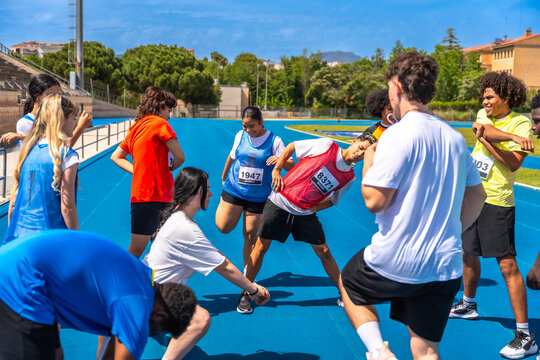 Young athletes stretching together before a track race