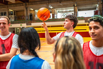 Basketball player spinning ball on finger during training with teammates