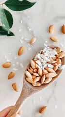 Close-up of wooden spoon scooping almonds coated in coconut flakes for plant-based snacks