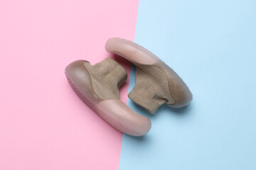 First baby shoes on pink blue background. Top view