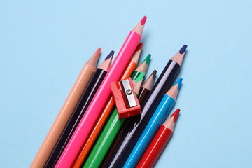 Set of wooden colored pencils with sharpener on blue background