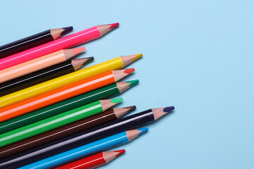 Set of wooden colored pencils on blue background