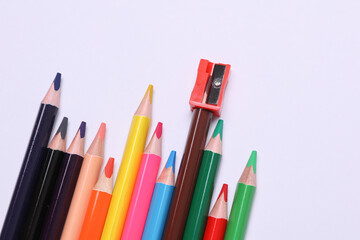 Set of wooden colored pencils with sharpener on gray background