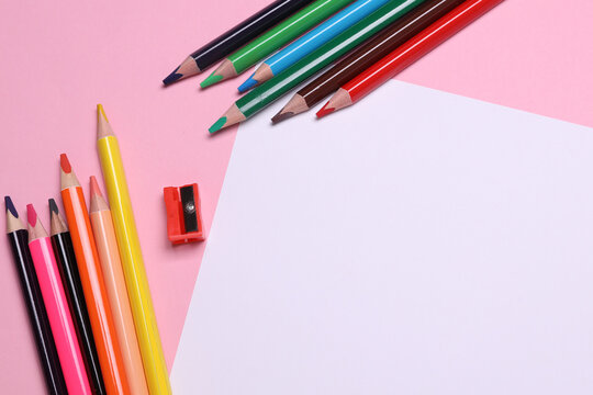 White paper sheet and Set of wooden colored pencils with sharpener on pink background - Powered by Adobe