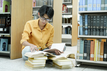Student Of University Choosing Book and Reading Book In Library.