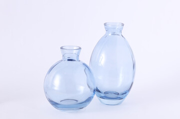 Two blue glass vases on a white background. Minimalistic aesthetic still life.